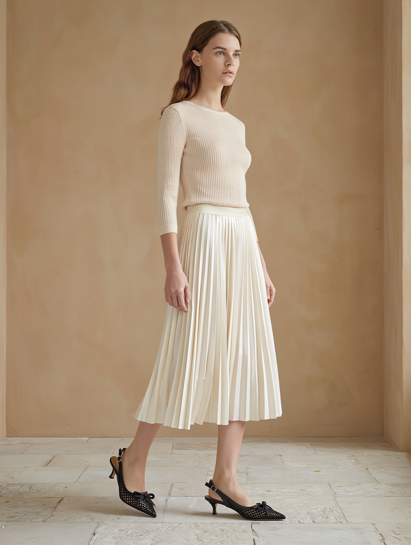 A model in a cream pleated skirt wearing the New Woven Heels in black