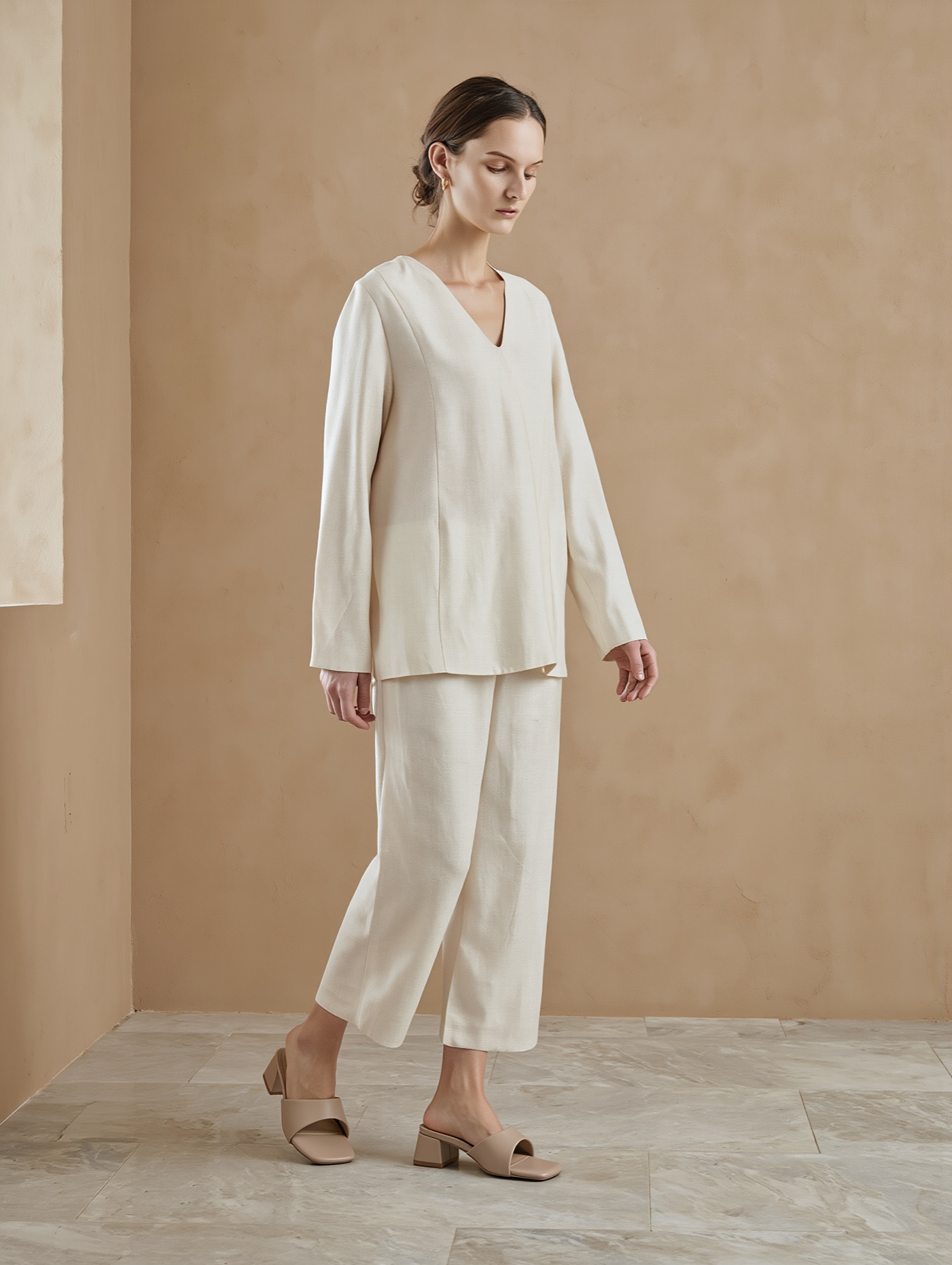 A model in an ivory linen trouser suit wearing the OpenBlock Comfort Heels in nude